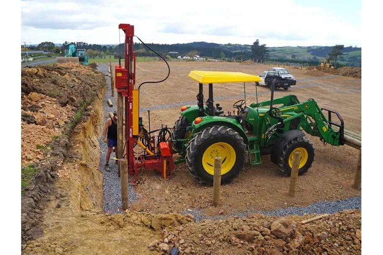 Telescoping post driver by guide wire John Deere with loader and forks
