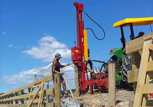 Fencing contractor constructing new wooden yards with Kinghitter post driver